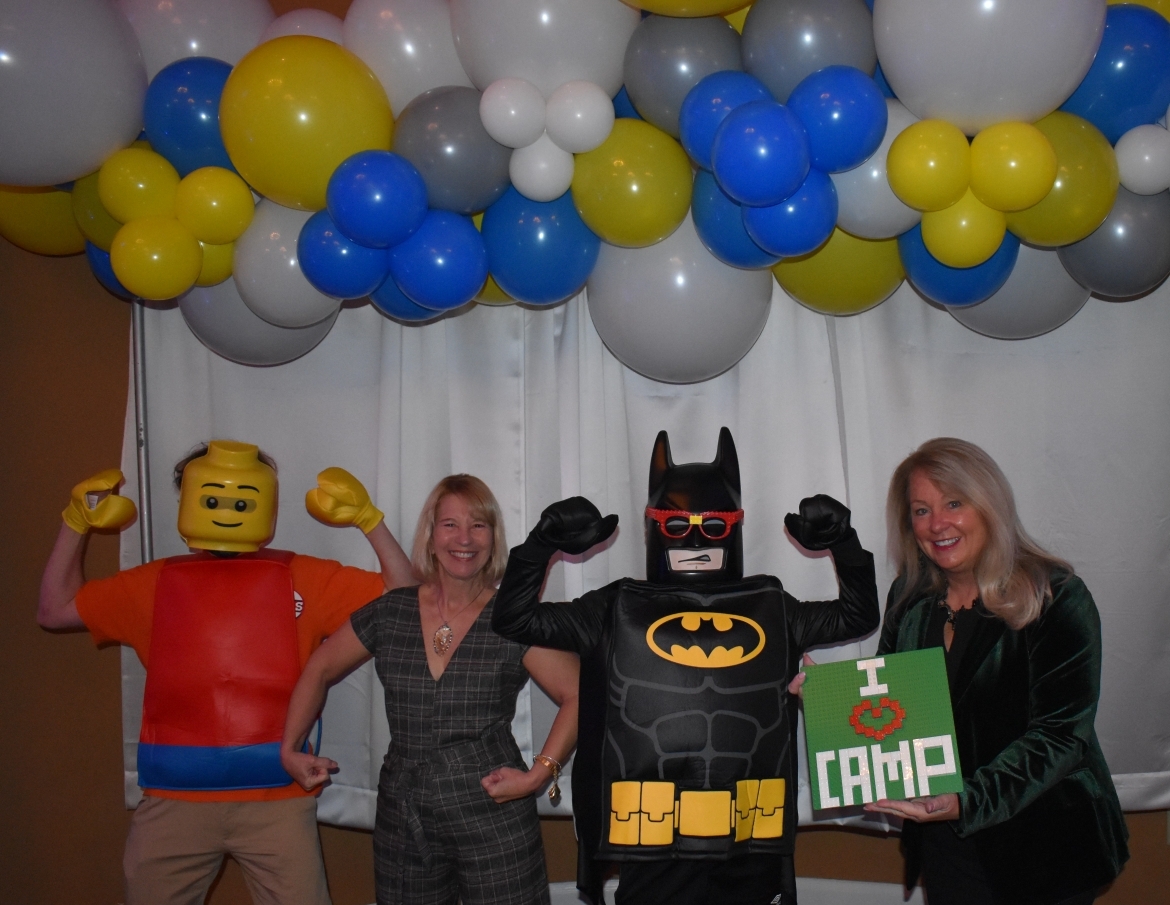 Two people with Batman and LEGO Man and "I love camp" sign